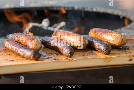 Würstchen auf Cutting Board und Barbecue grill Stockfoto