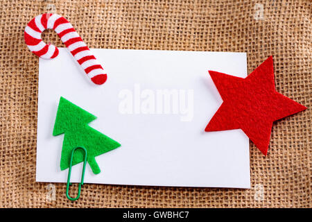 Leere Karte mit Weihnachten Filz Dekorationen auf Jute Hintergrund. Stockfoto