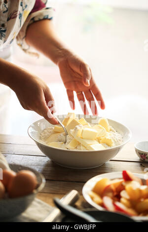 Frau, die Butter und Mehl mischt Stockfoto