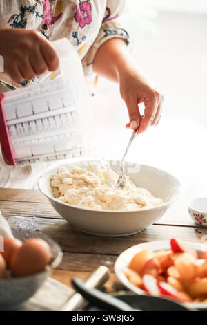 Frau, die Butter und Mehl mischt Stockfoto