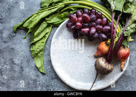 Frisch geerntete Rüben und roten Trauben werden aus der Ansicht von oben fotografiert. Stockfoto