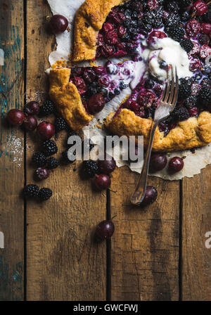 Hausgemachte Garten Berry Galetta oder Crostata süßen Kuchen mit zerlassener Vanille Eis Kugel serviert mit frischen Beeren auf rustikalen Holz Stockfoto