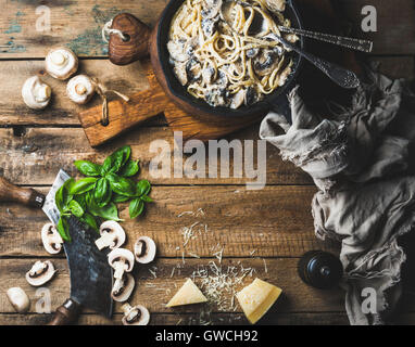 Abendessen im italienischen Stil mit Textfreiraum. Cremige Champignon Nudeln Spaghetti in Gusseisen Pfanne mit Parmesan-Käse, frischem Basilikum und pep Stockfoto