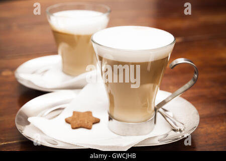 Glas Tassen Cappuccino voller stehen auf Holztisch. Nahaufnahme Foto mit selektiver Weichzeichner Stockfoto