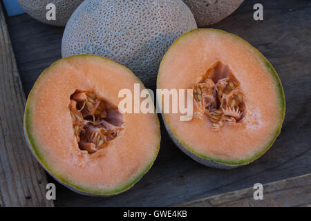 Bio Melone schneiden halbieren und auf dem Display auf einem Bauernmarkt in Monterey, Kalifornien. Stockfoto