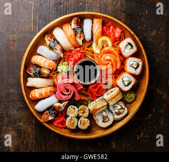 Sushi Set Rollen, Nigiri und Sashimi serviert Runde Tablett aus Holz Stockfoto