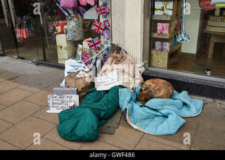 Edinburgh, UK. Junge Obdachlose schlafen auf dem Bürgersteig in eine Decke gehüllt. Neben ihrem Schlaf handgeschriebene ihr A kleine post Stockfoto