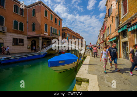 MURANO, Italien - 16. Juni 2015: Murano steinerne Brücke inmitten von Kanälen, blaue Transport Boot und Touristen Stockfoto