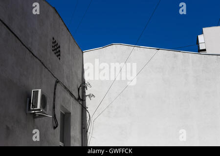 Alte graue Stuck Mauerbau auf dem Hintergrund des blauen Himmels, Stadt abstrakt Stockfoto