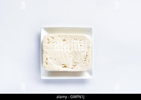 Tofu auf einem weißen Teller auf einer weißen Tafel, frische vegetarische Nahrung, Fleischersatz Stockfoto