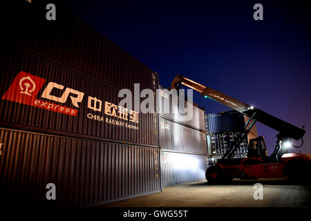 (160914)--Peking, 14. September 2016 (Xinhua)--Personal Mitglieder ein Containers, getragen von der China Railway Express zwischen Zhengzhou und Europa in Zhengzhou, Hauptstadt der Provinz Zentral-China Henan, 18. August 2016 übertragen.  Zhengzhou ist eine der chinesischen Städte haben direkte Güterzüge nach Europa. Ausgehend von Zhengzhou, Center und Transport Logistikdrehscheibe in Henan, die 10.214 km Zhengzhou-Europe internationale Shuttle-Zug die Grenze am Alataw-Pass in Xinjiang kreuzt vor der Übergabe durch Kasachstan, Russland, Weißrussland und Polen auf dem Weg zu Deutschlands Hamburg.  Zhengzhou-Eur Stockfoto