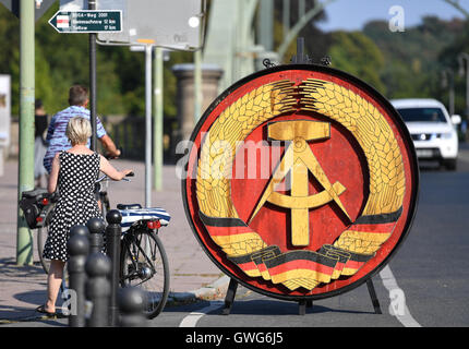 Potsdam, Deutschland. 14. Sep, 2016. Das ehemalige Staatswappen der DDR, eine originale Requisite aus dem Steven Spielberg Film "Agentenbrücke", steht in der Nähe der Glienicker Brücke in Potsdam, Deutschland, 14. September 2016. Das nationale Emblem hing in der Mitte der Brücke in DDR-Zeiten und werden in Zukunft auf dem Display an Villa Schoningen. Foto: RALF HIRSCHBERGER/Dpa/Alamy Live News Stockfoto