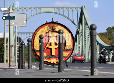 Potsdam, Deutschland. 14. Sep, 2016. Das ehemalige Staatswappen der DDR, eine originale Requisite aus dem Steven Spielberg Film "Agentenbrücke", steht in der Nähe der Glienicker Brücke in Potsdam, Deutschland, 14. September 2016. Das nationale Emblem hing in der Mitte der Brücke in DDR-Zeiten und werden in Zukunft auf dem Display an Villa Schoningen. Foto: RALF HIRSCHBERGER/Dpa/Alamy Live News Stockfoto