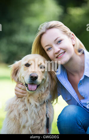 Frau umarmt Haustier Golden Retriever Stockfoto