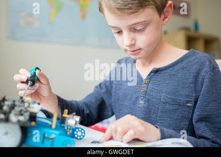 Junge Montage Roboter Kit im Schlafzimmer Stockfoto