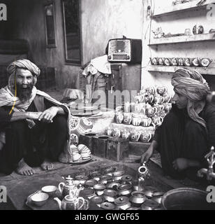 1950er-Jahren, historische, zwei lokale Afghanen sitzen mit ihren Zinn waren, Kabul, Afghanistan. Stockfoto