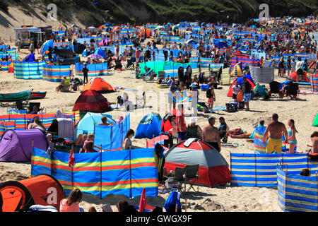 Der Strand voll mit Urlaubern und Windschutze Harlyn Bay, North Cornwall. Stockfoto