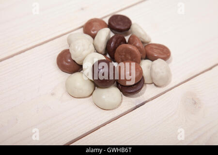 Haufen von niederländischen Süßigkeiten Schokolade Pepernoten auf weißem Holz Hintergrund Stockfoto