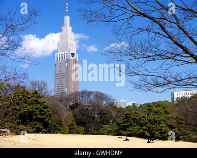 Meiji-Schrein-Park mit NTT Docomo Gebäude im Hintergrund an einem sonnigen blauen Himmel Tag, Tokyo, Japan Stockfoto