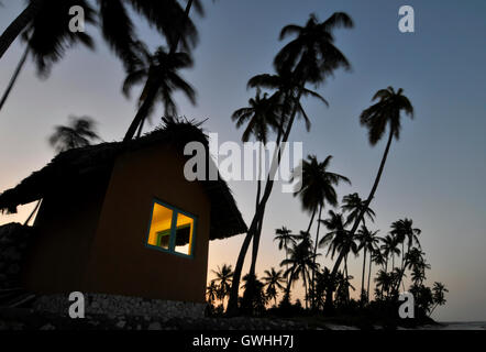 Eine einsame Hütte mit Bäumen Silhouette bei Sonnenuntergang. Stockfoto