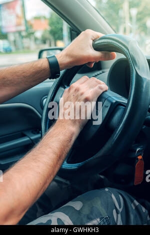 Nervös männliche Fahrer schieben Autohupe Traffic Rush hour, hautnah mit selektiven Fokus auf Hand am Lenkrad Stockfoto