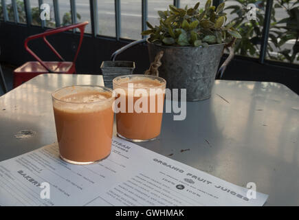 Gläser mit frisch gepresstem Karottensaft. Bio-Ware verkauft im Woki Bio Market Place Catalunya in Barcelona. Stockfoto