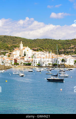 Weiß getünchte Cadaques Stadt, Spanien, gekrönt von der Kirche Santa Maria mit Blick auf Boote in den blauen Wassern der Bucht von Cadaqués, Spanien Stockfoto