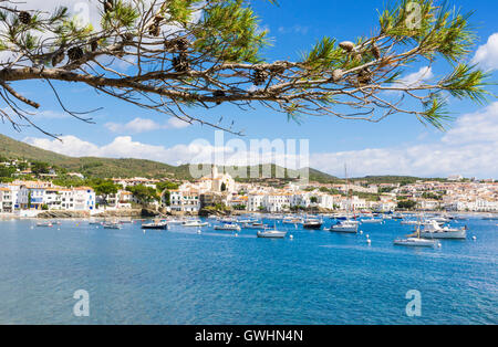 Weiß getünchten Dorf Cadaqués gekrönt von der Kirche Santa Maria mit Blick auf Boote in den blauen Wassern der Bucht von Cadaqués, Spanien Stockfoto