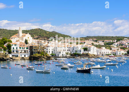 Weiß getünchte Cadaques-Stadt, gekrönt von der Kirche Santa Maria mit Blick auf Boote in den blauen Wassern der Bucht von Cadaqués, Spanien Stockfoto