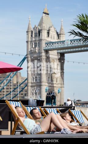 Menschen Sonnen Sie sich in der Nähe von Rathaus, auf der South Bank in London, wie es die heißesten Tag des Jahres so weit mit einer sengenden Temperatur von über 34 C - die aufregendsten September Tag in mehr als 100 Jahren. Stockfoto