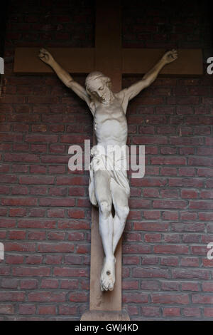 Statue von Jesus am Kreuz gegen roten Backsteinmauer in Belgien Stadt Gent Stockfoto