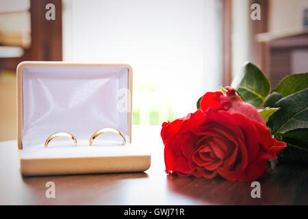 Trauringe im Fall für Ringe mit roter Rose. Ehe und Hochzeit-Konzept-Bild. Stockfoto