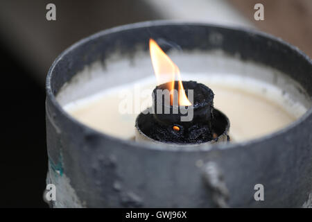 Einer kleinen Kerze Flamme brennendes Metall umgeben. Stockfoto