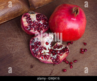 Reife offene Granatapfel auf hölzernen Hintergrund Stockfoto