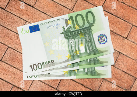100 Euro-Banknoten auf Ziegel-Hintergrund Stockfoto
