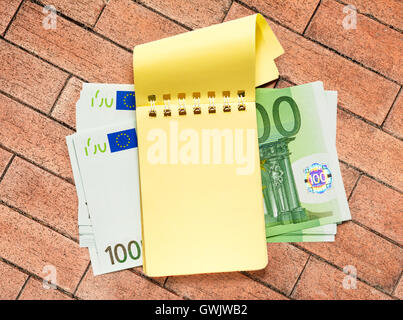 100 Euro-Banknoten und leeren gelben Notizblock Stockfoto