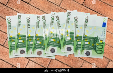 100 Euro-Banknoten auf Ziegel-Hintergrund Stockfoto