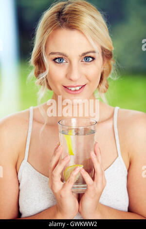 Mädchen trinken Glas Eiswasser mit Zitrone Stockfoto