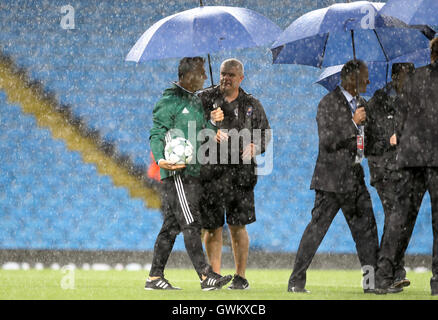 Schiedsrichter Björn Kuipers und Kopf Platzwart Lee Jackson inspizieren die Tonhöhe bei starkem Regen vor dem Champions-League-Spiel im Etihad Stadium Manchester. Stockfoto