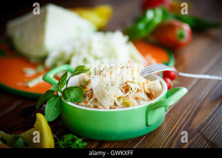 Sauerkraut mit Karotten in eine Schüssel geben Stockfoto