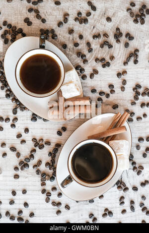 Tasse Kaffee mit Getreide, Croissant, türkischem Honig und Zimt klebt auf hölzernen Hintergrund Stockfoto