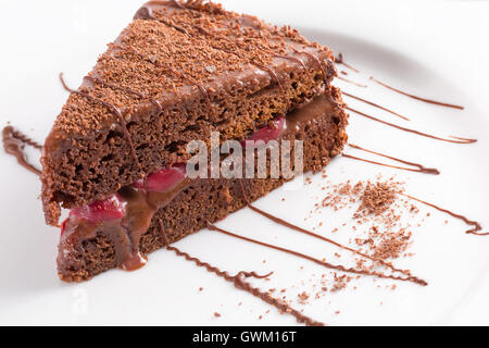 Schokoladen-Käsekuchen mit Kirschen auf weißen Teller. Stockfoto