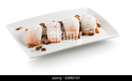 Pastetchen mit Rosinen auf weißen Teller auf dem weißen Hintergrund isoliert. Stockfoto