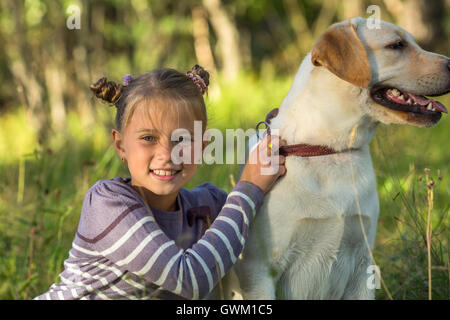 Kleines Mädchen auf einem Spaziergang mit dem Hund. Stockfoto