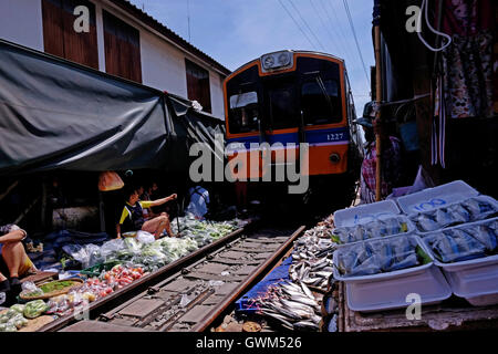 Ein Zug auf der Durchreise Maeklong Railway Markt in Samut Songkhram, rund 37 Meilen westlich von Bangkok, Thailand Stockfoto