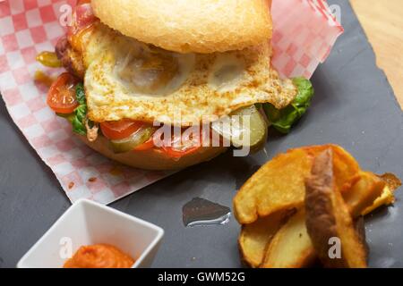 Rindfleisch-Burger mit Spiegelei und Pommes Frites. Stockfoto