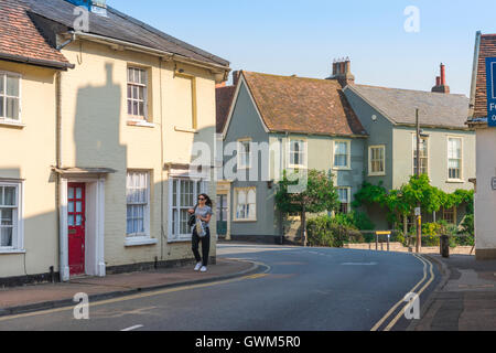 Suffolk village Klara, eine junge Frau die Spaziergänge entlang der Nethergate Straße im Zentrum der Suffolk Dorf Clare, Dielsdorf district, England, UK. Stockfoto