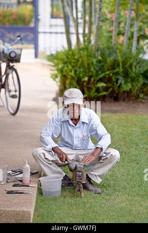 Messerschleifer. 75-jähriger älterer Mann bei der Arbeit, der Haushaltsgeräte schärft. Thailand S. E. Asien Stockfoto