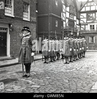 1950er Jahre historische, Line-up von Yeomen Warders of Her Majesty königlicher Palast und Festung der Tower of London, bekannt im Volksmund als Beefeaters. Stockfoto
