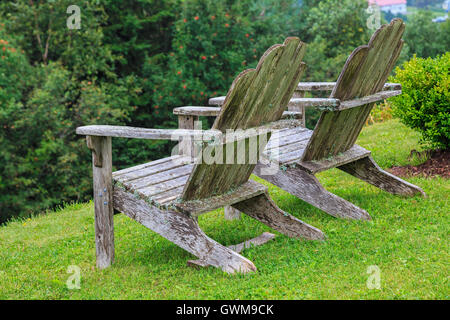 Verwitterte Gartenmöbel Adirondack in Moos und Flechten bedeckt. Stockfoto